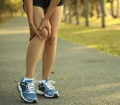 Runner holding their knee in pain
